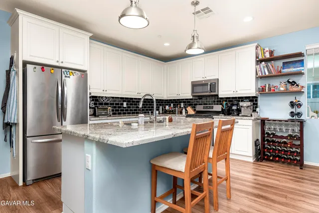 a kitchen with stainless steel appliances granite countertop a stove and a refrigerator