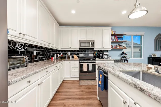a kitchen with stainless steel appliances granite countertop a stove sink and cabinets