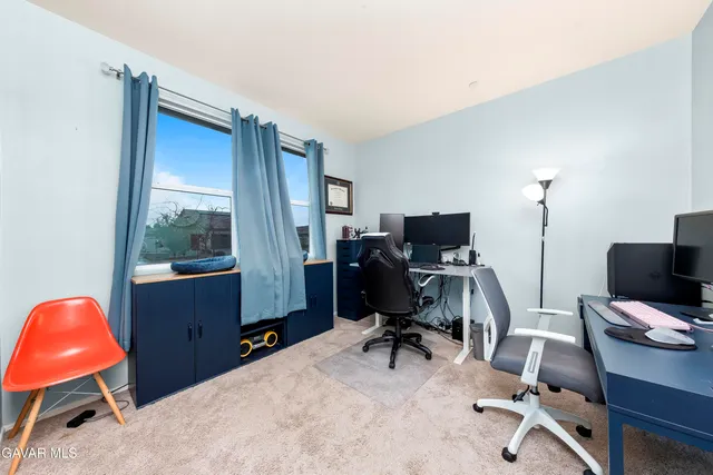 a view of a workspace with furniture and a window