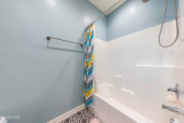 a bathroom with a white bathtub and a shower