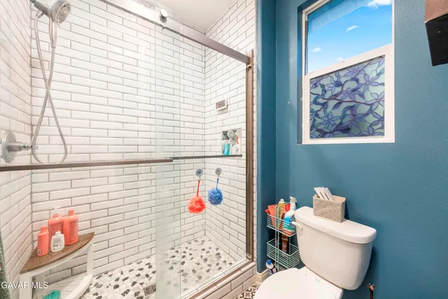 a bathroom with a toilet and a shower curtain