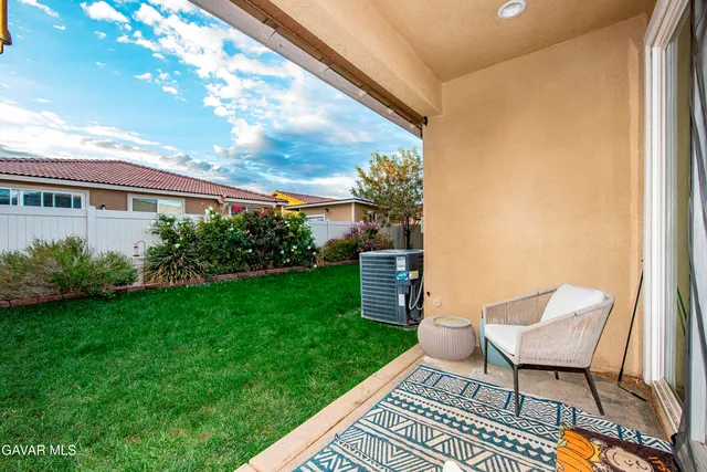 a view of a chair and table in backyard of the house