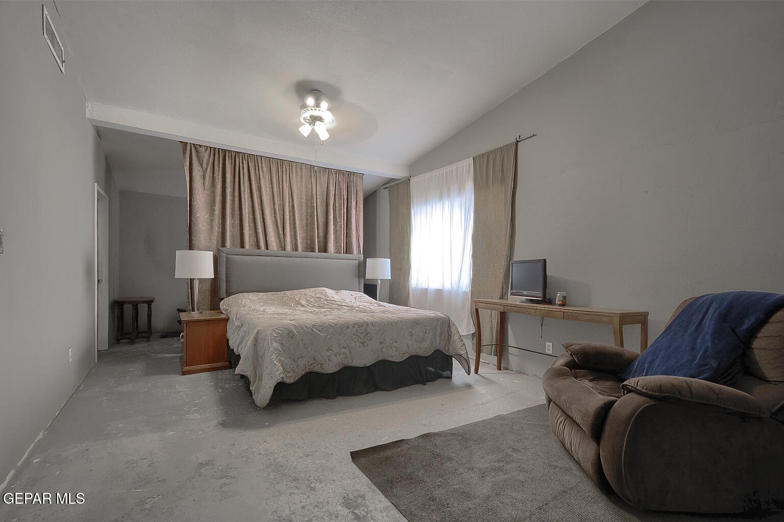 261 Indian Head Road Tornillo, TX 79853 - Photo 22 of 44 a bed sitting in a spacious bedroom next to a window and a couch