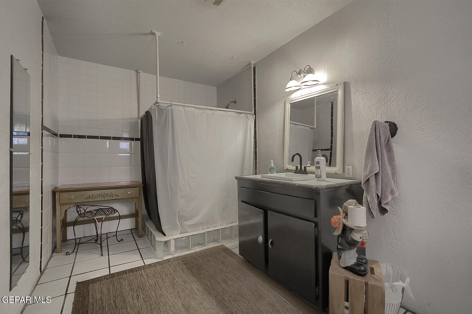 261 Indian Head Road Tornillo, TX 79853 - Photo 24 of 44 a bathroom with a sink a mirror a lamp and a shower