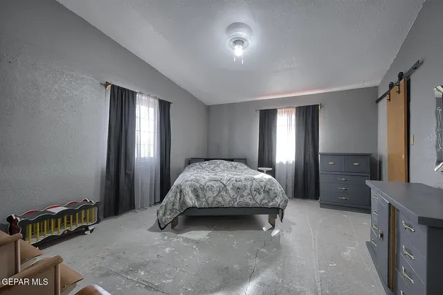 a spacious bedroom with a bed and a dresser in it