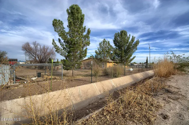 a view of a dirt yard with a fountain