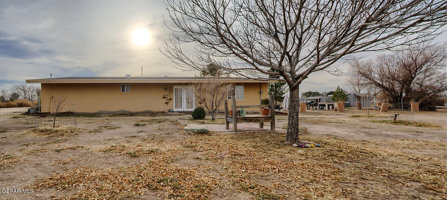 261 Indian Head Road Tornillo, TX 79853 - Photo 41 of 44 a view of a backyard with table and chairs under a large tree