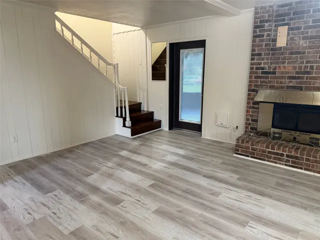 a view of empty room with stairs and wooden floor