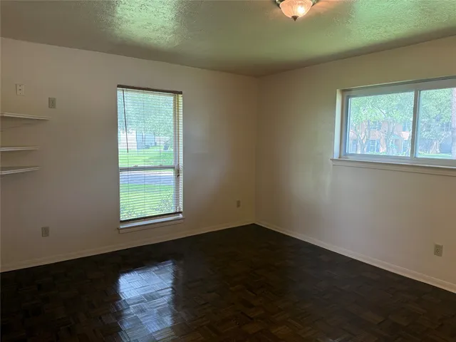 an empty room with wooden floor and a window