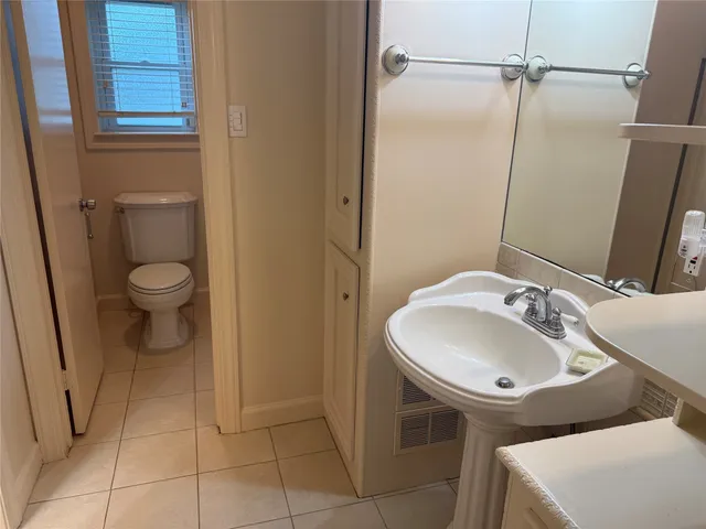 a bathroom with a sink a toilet and a mirror
