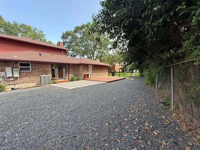 a view of a house with backyard and trees