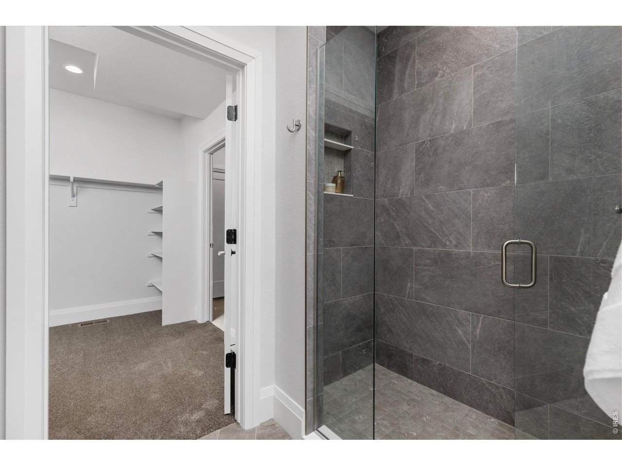 5700 West 2nd Street Road Greeley, CO 80634 - Photo 20 of 40 Floor-to-ceiling tile in the large primary ensuite bathroom's shower