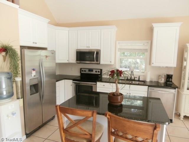 512 Riverview Road Lexington, NC 27292 - Photo 12 of 30 Kitchen has tile flooring and the island has a breakfast bar.