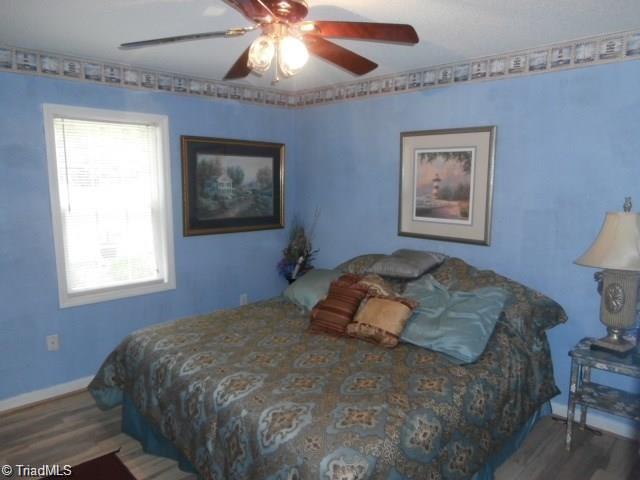 512 Riverview Road Lexington, NC 27292 - Photo 18 of 30 Large second bedroom with a ceiling fan, double closet, and laminate floors.