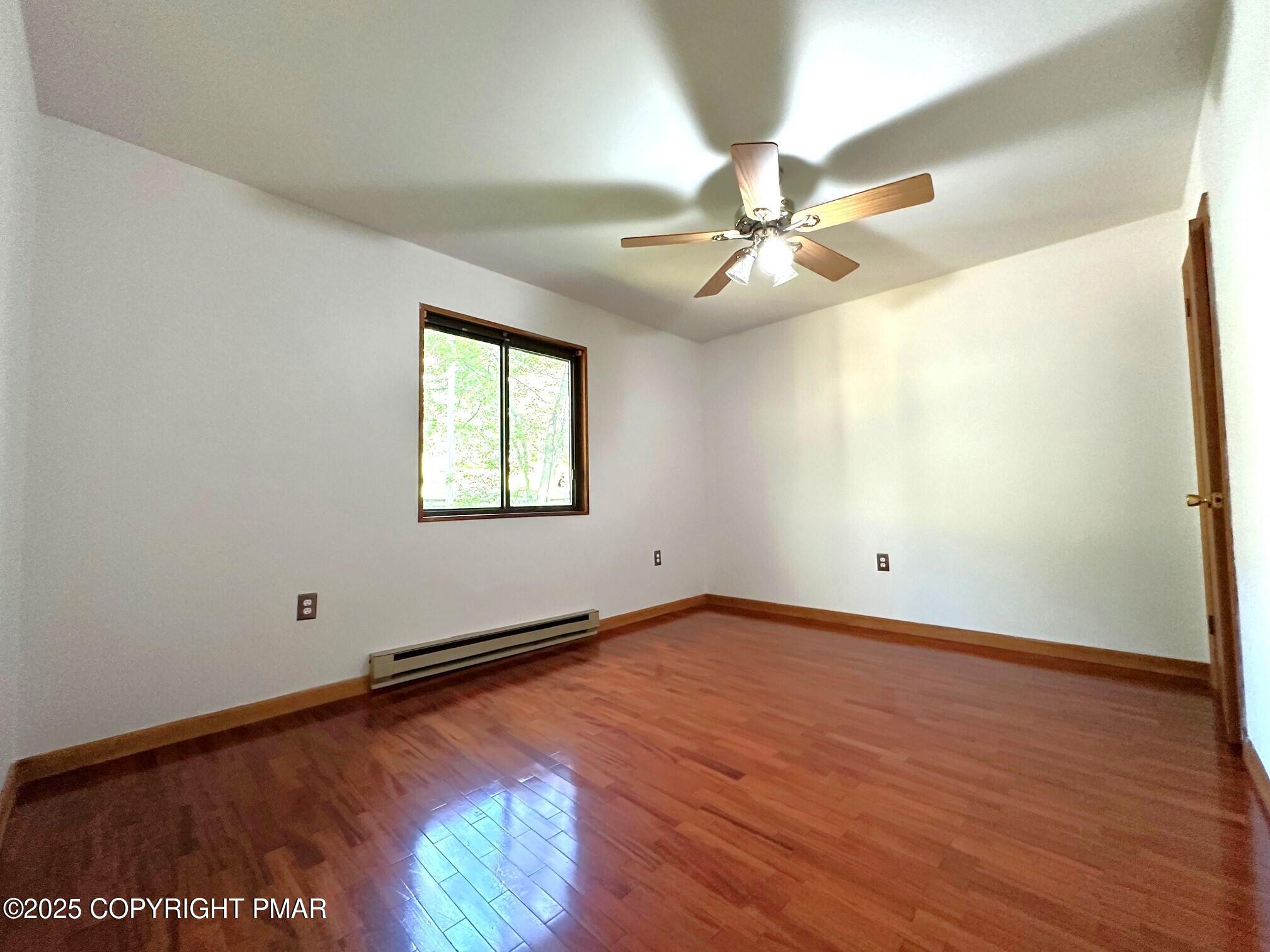 344 Pocono Boulevard, Unit 344 Bushkill, PA 18324 - Photo 12 of 20 an empty room with wooden floor fan and windows