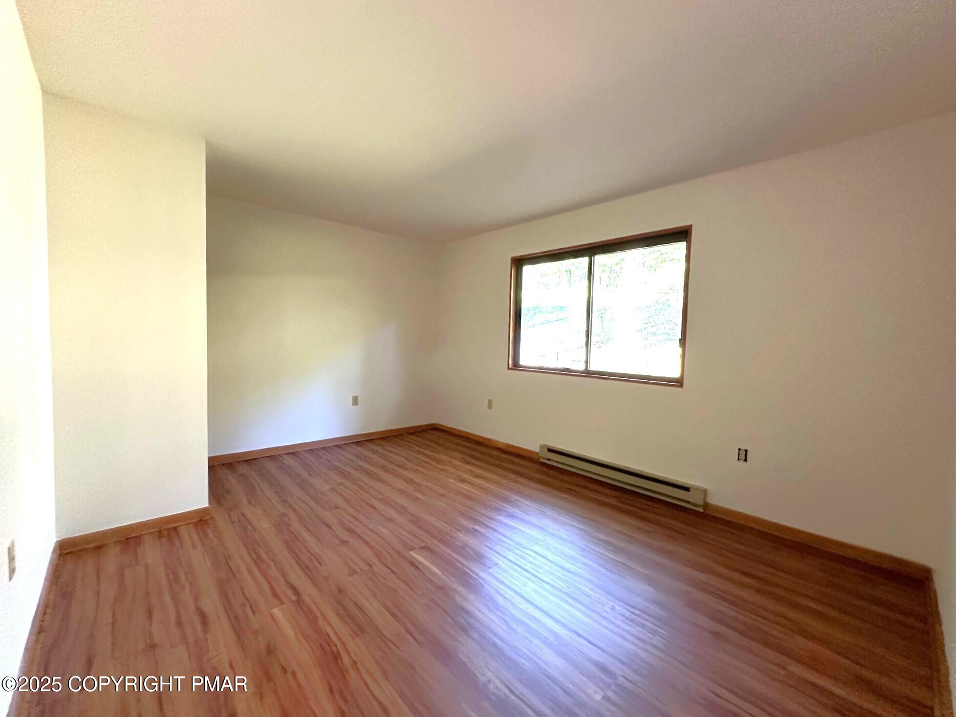 344 Pocono Boulevard, Unit 344 Bushkill, PA 18324 - Photo 13 of 20 an empty room with wooden floor and windows