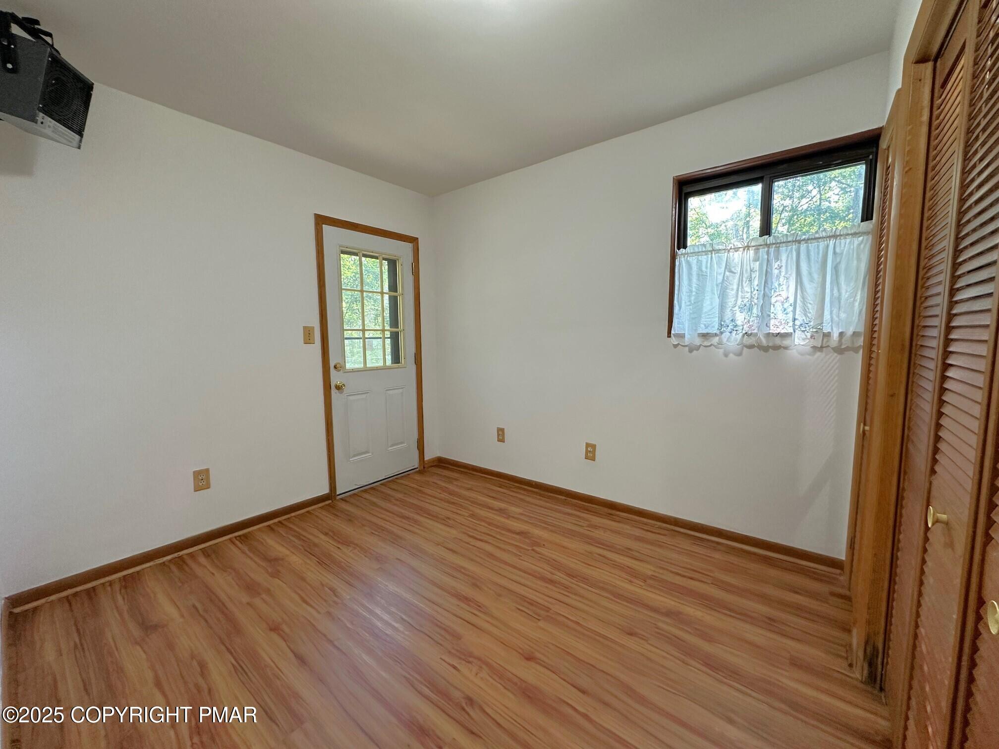 344 Pocono Boulevard, Unit 344 Bushkill, PA 18324 - Photo 16 of 20 an empty room with wooden floor and windows
