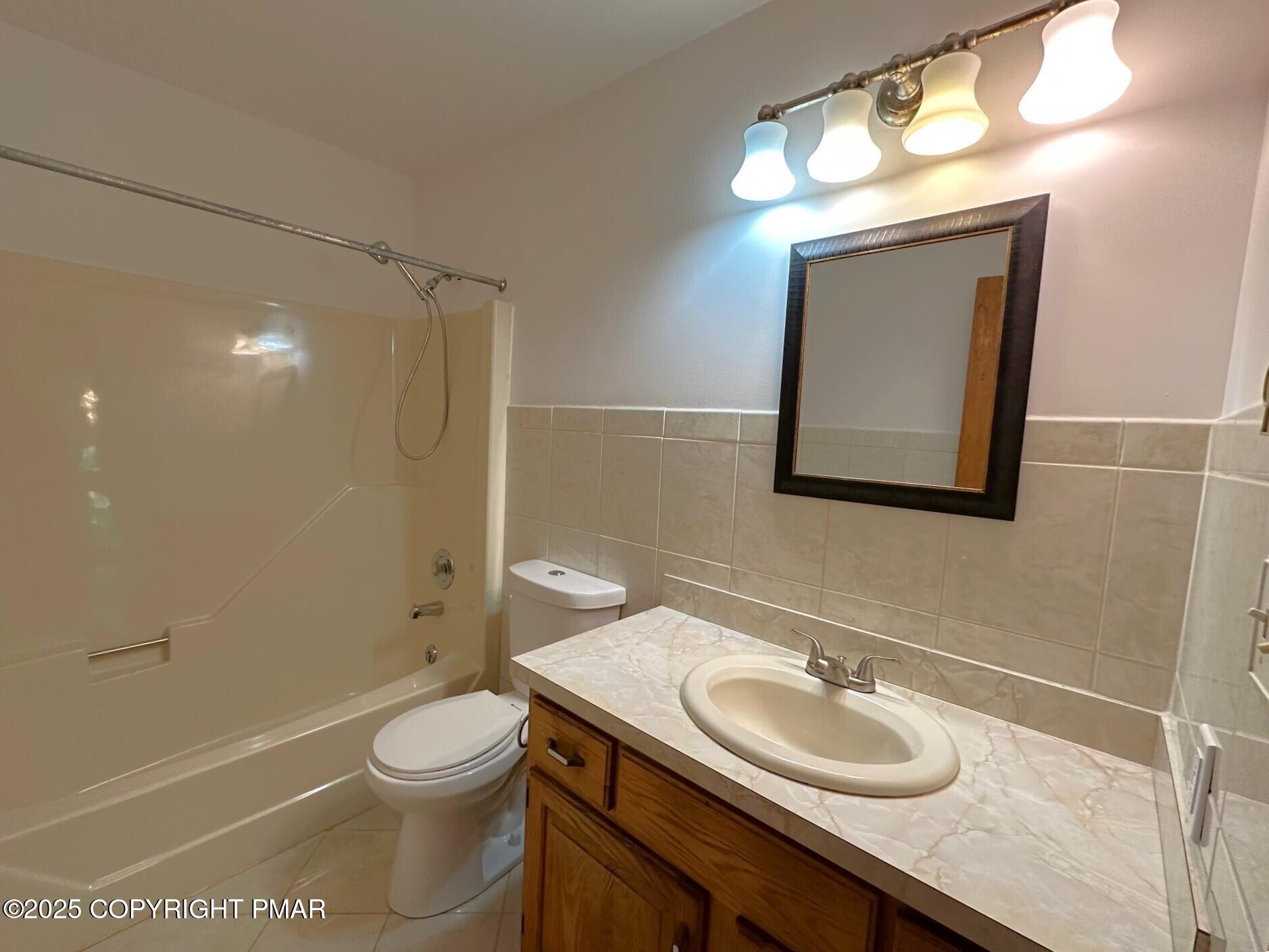 344 Pocono Boulevard, Unit 344 Bushkill, PA 18324 - Photo 10 of 20 a bathroom with a granite countertop sink toilet a mirror and shower