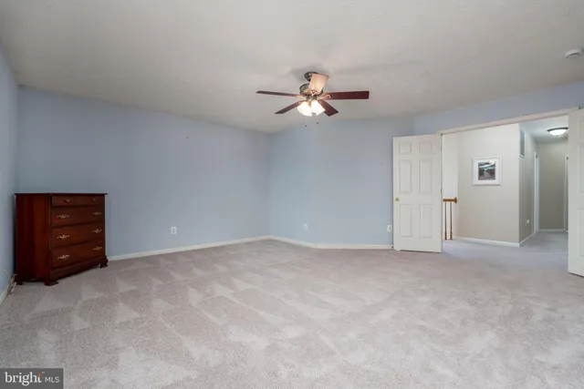 a view of an empty room with a ceiling fan