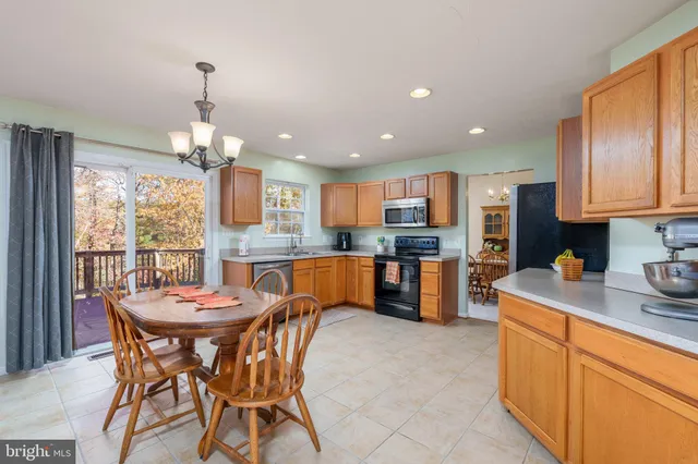 a kitchen with stainless steel appliances kitchen island granite countertop a sink and a refrigerator