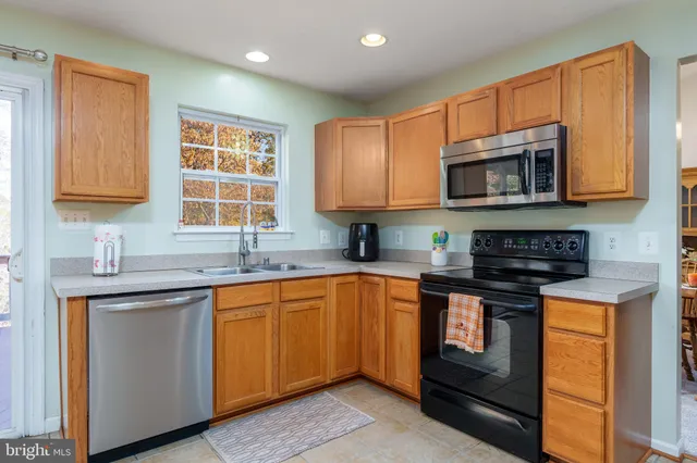 a kitchen with stainless steel appliances granite countertop a stove sink microwave and cabinets