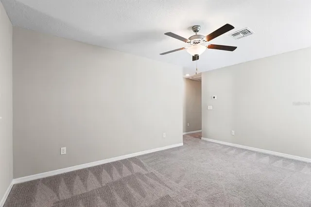an empty room with a ceiling fan and a ceiling fan