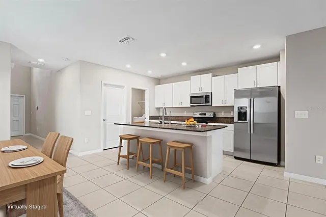 a kitchen with granite countertop a sink a stove top oven and cabinets