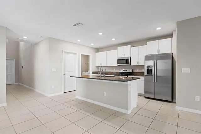 a kitchen with granite countertop white cabinets and stainless steel appliances