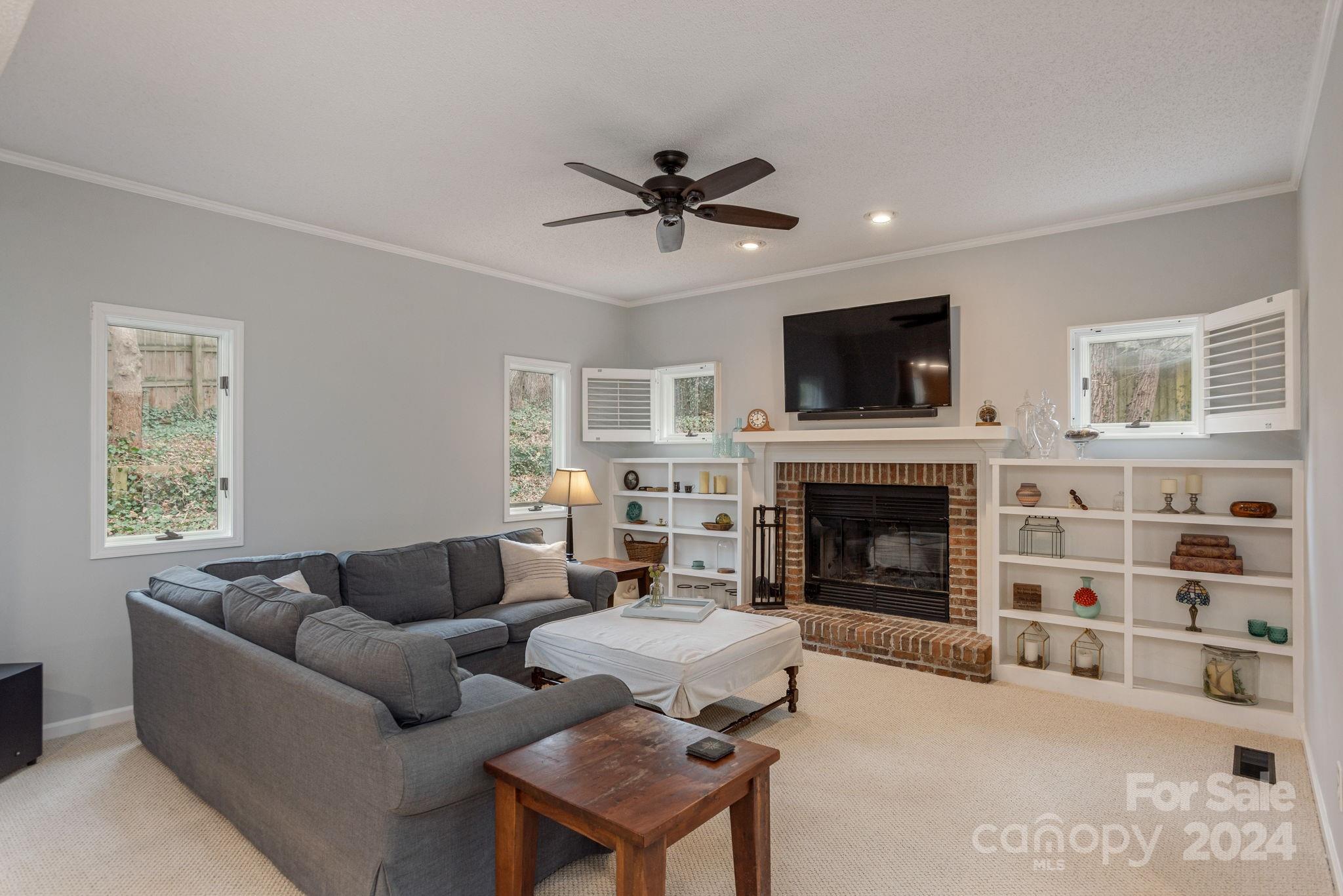 21 Spring Cove Court Arden, NC 28704 - Photo 13 of 32 a living room with furniture a fireplace and a flat screen tv