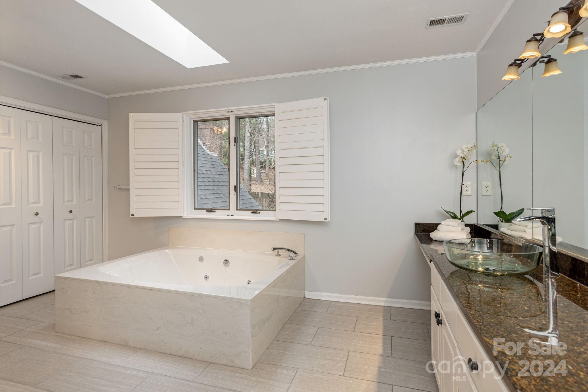 21 Spring Cove Court Arden, NC 28704 - Photo 20 of 32 a bathroom with a granite countertop sink a mirror and a bathtub