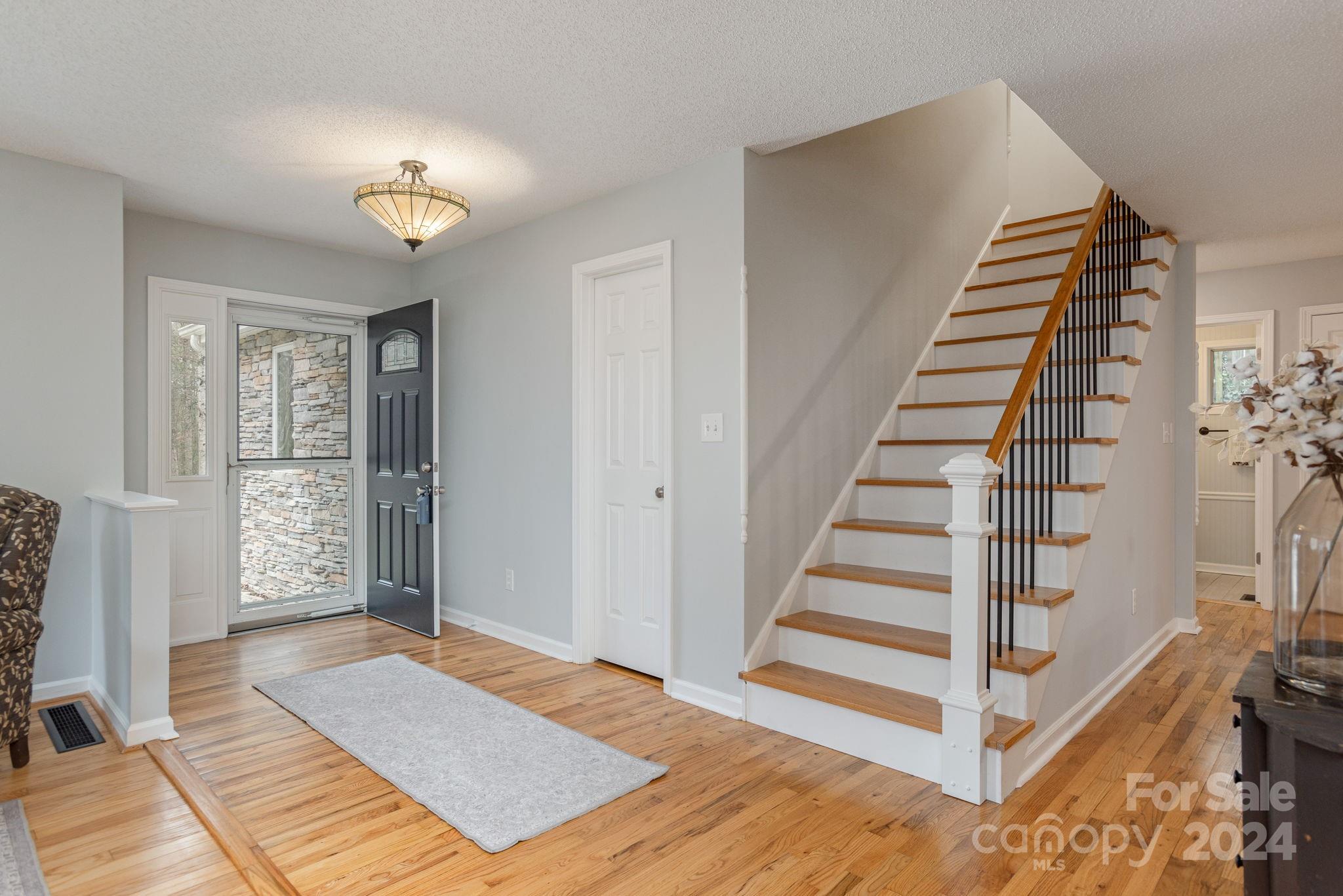 21 Spring Cove Court Arden, NC 28704 - Photo 2 of 32 a view of a bedroom with wooden floor and stairs