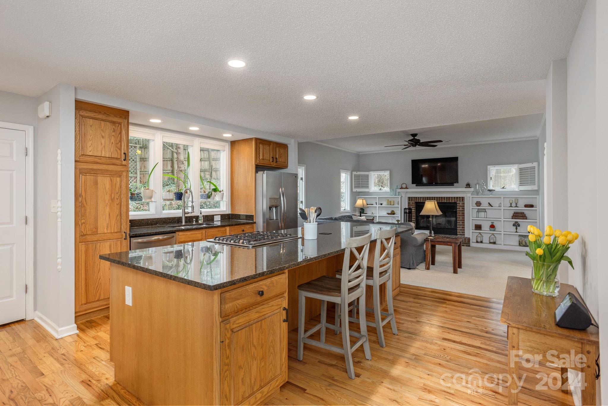 21 Spring Cove Court Arden, NC 28704 - Photo 9 of 32 a dining hall with stainless steel appliances granite countertop a sink a stove a dining table and chairs with wooden floor