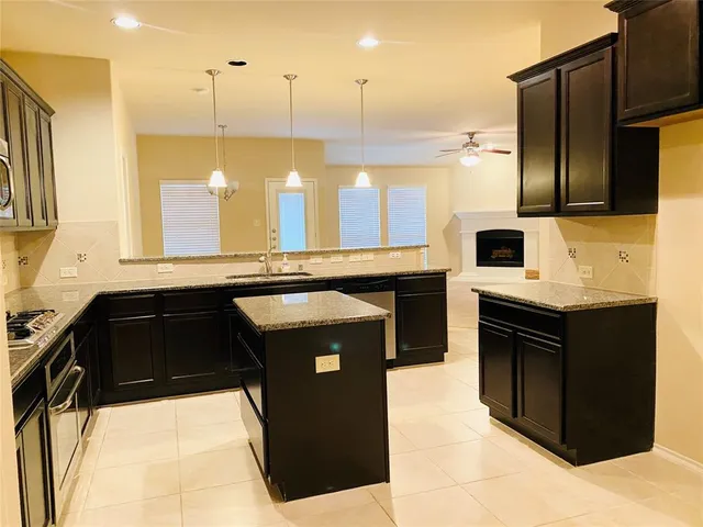 a kitchen with a sink a stove and cabinets