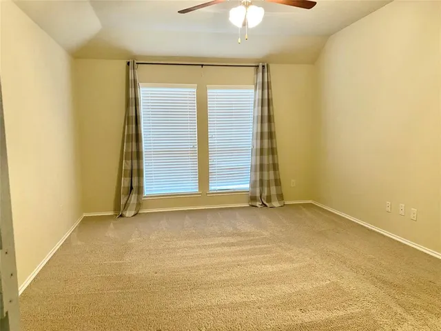 an empty room with a empty space and a ceiling fan