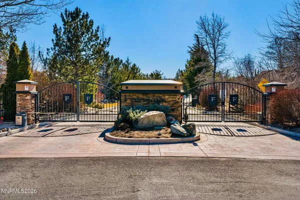 a front view of a building with garden and trees