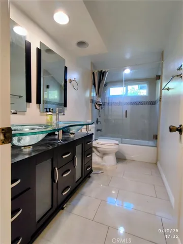a bathroom with a double vanity sink a toilet and a mirror