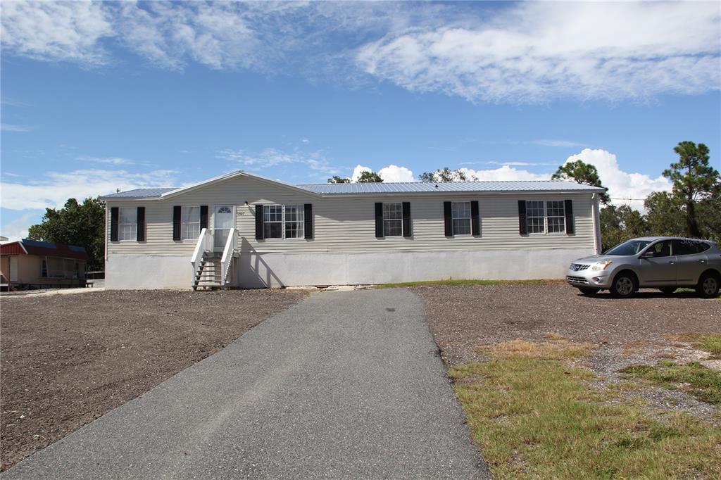 13127 Star Road Brooksville, FL 34613 - Photo 40 of 54 a front view of a house with a yard and garage