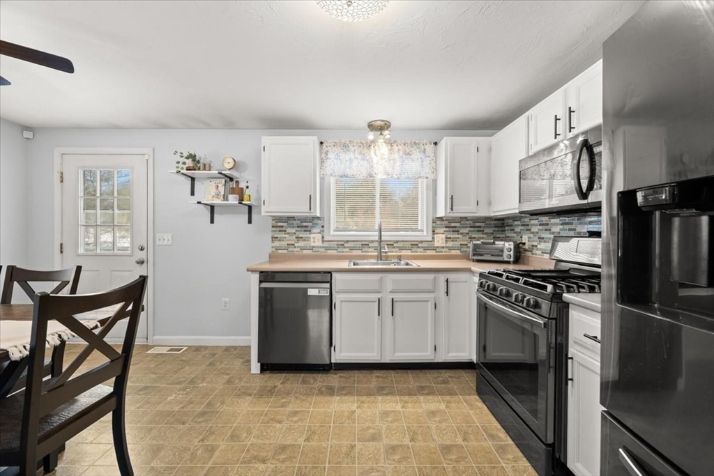143 Morrison Road East Taunton, MA 02718 - Photo 7 of 31 a kitchen with granite countertop a stove top oven cabinets and a refrigerator