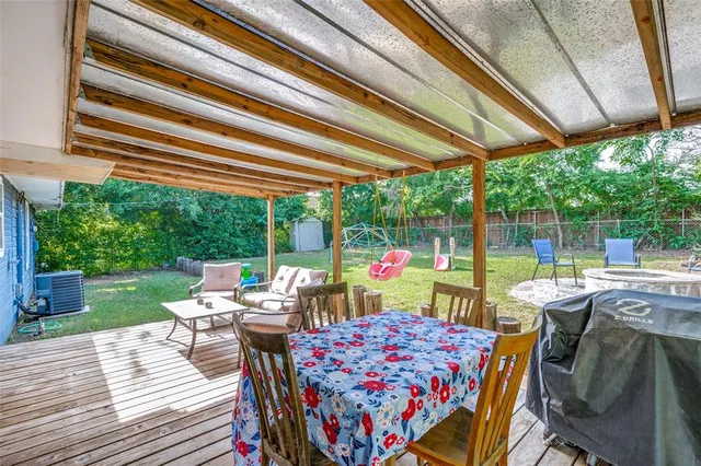 a view of a patio with table and chairs potted plants with wooden floor and fence
