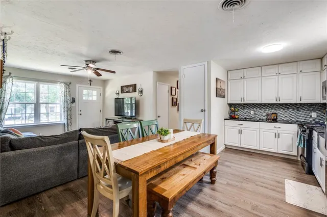 a living room with stainless steel appliances kitchen island granite countertop furniture and wooden floor