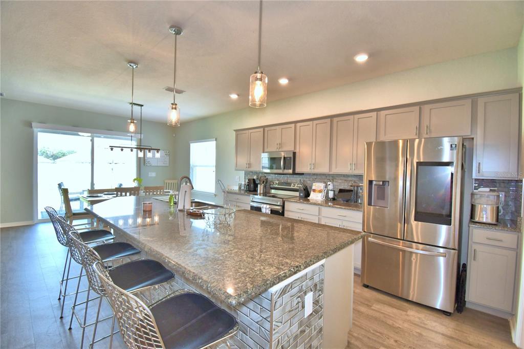 4340 Reding Way Lakeland, FL 33813 - Photo 37 of 63 a kitchen with stainless steel appliances granite countertop a sink a stove a refrigerator cabinets and chairs
