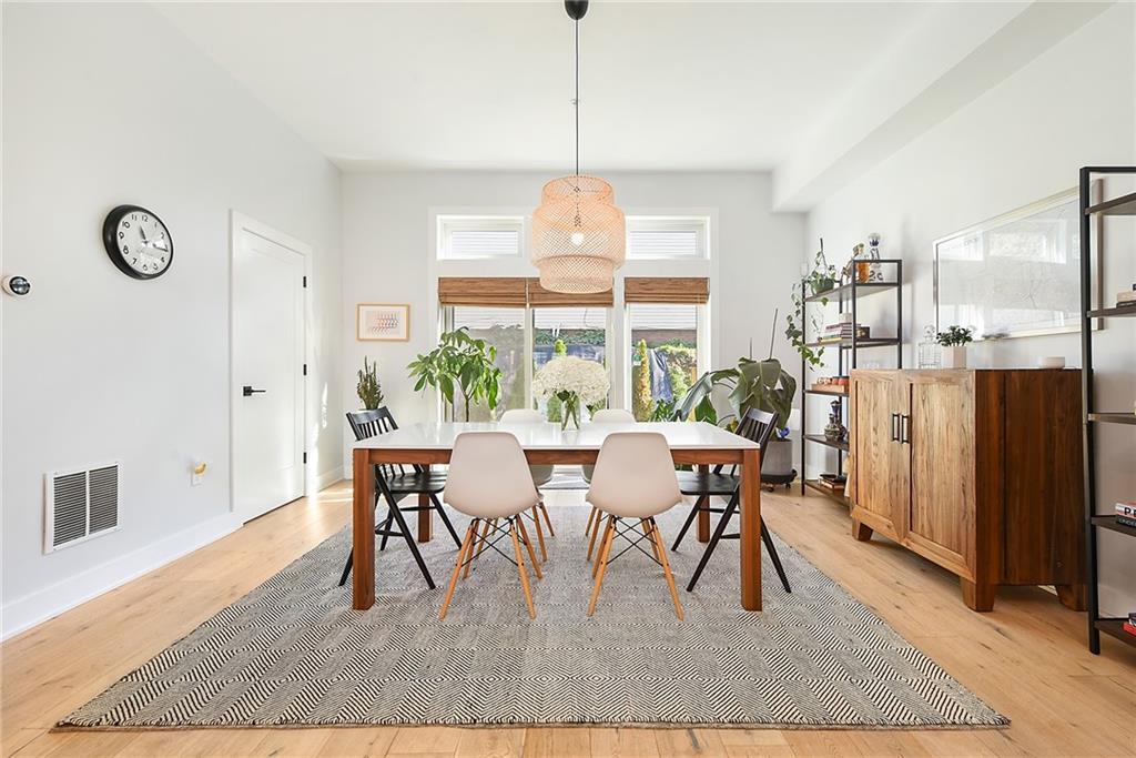 313 38th Street Pittsburgh, PA 15201 - Photo 12 of 25 a dining room with wooden floor a chandelier a wooden table and chairs