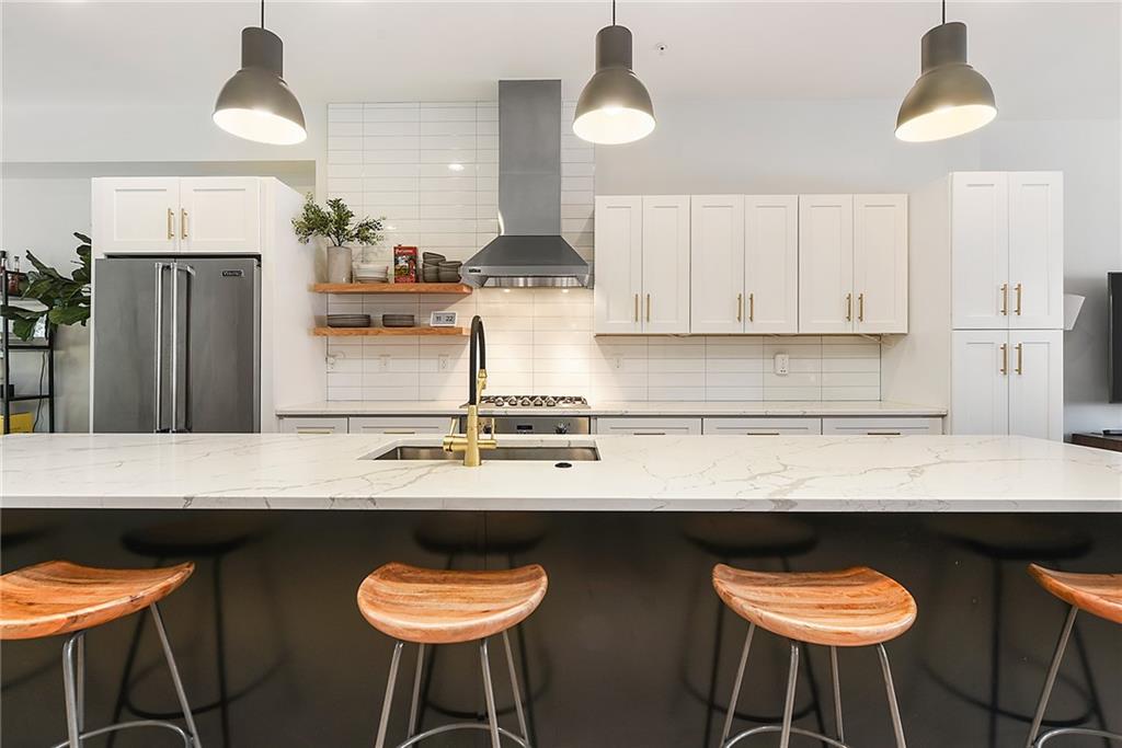 313 38th Street Pittsburgh, PA 15201 - Photo 3 of 25 a kitchen with stainless steel appliances kitchen island a table and chairs in it