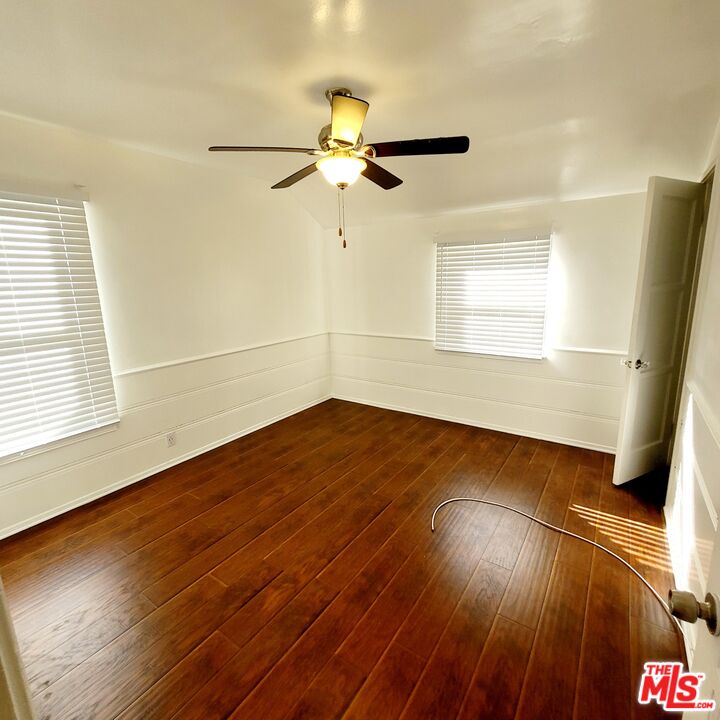 3760 Wellington Road Los Angeles, CA 90016 - Photo 14 of 52 an empty room with wooden floor fan and windows