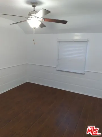 a view of a room with wooden floor and a ceiling fan