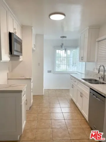 a kitchen with stainless steel appliances granite countertop a sink and a stove top oven