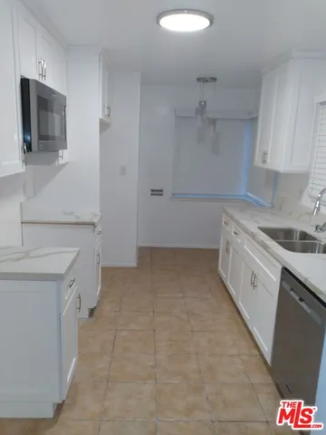a kitchen with stainless steel appliances granite countertop a sink and a microwave
