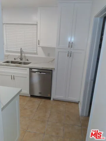 a kitchen with a sink window and cabinets