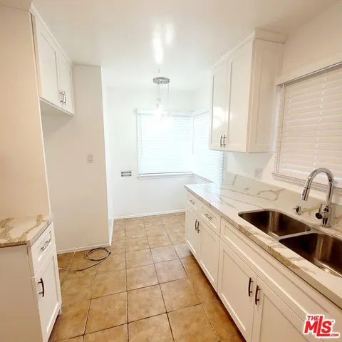 a white sink sitting under a bathroom window