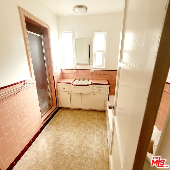3760 Wellington Road Los Angeles, CA 90016 - Photo 36 of 52 a bathroom with a sink a mirror and a bathtub
